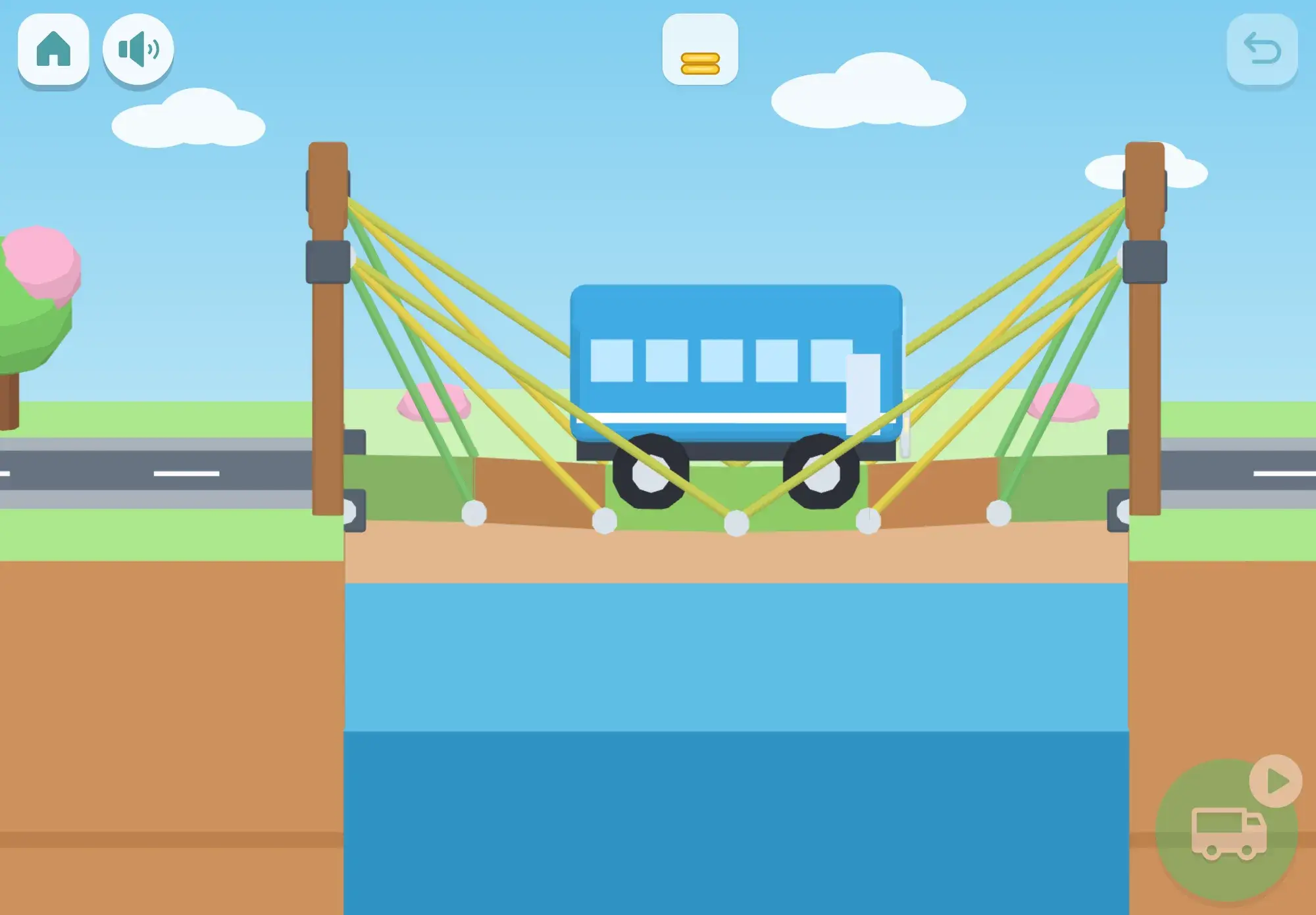 A blue bus drives across a cable bridge the child built over the river, its cables glowing yellow and green to show which ones take the weight